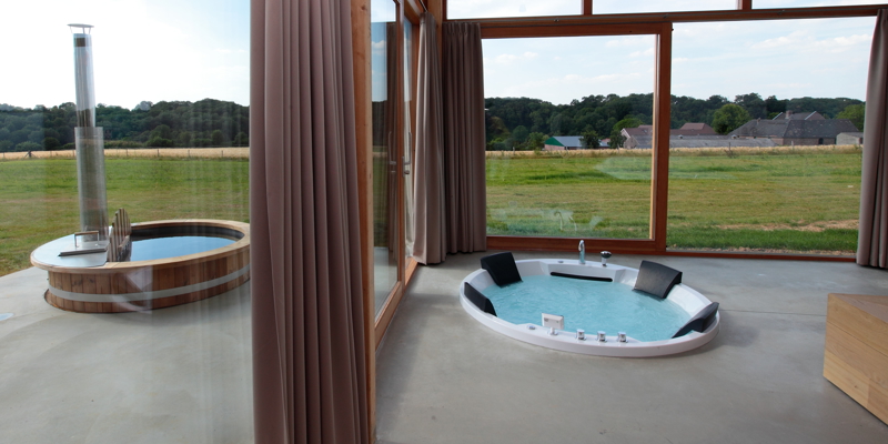 Luxe hotelkamer met een bubbelbad in de grond en een bubbelbad buiten. 